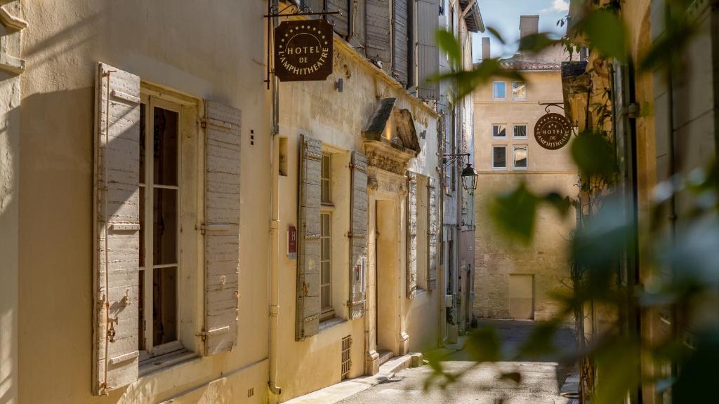 Un callejón en un casco antiguo con edificios. en Hôtel Amphithéâtre, en Arles