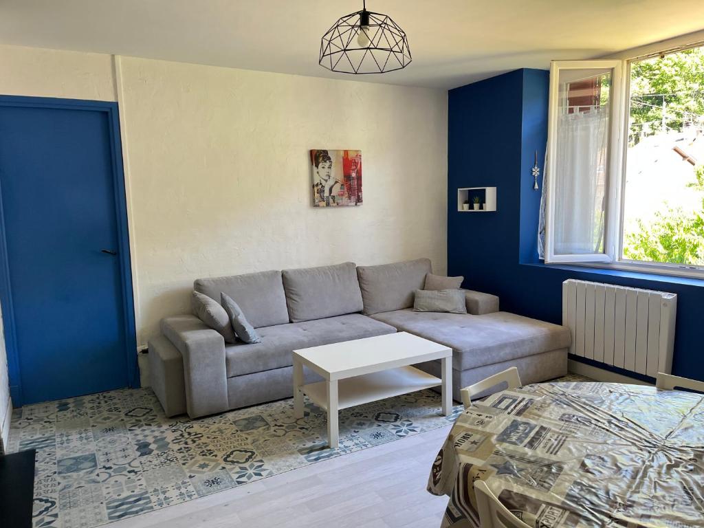 un soggiorno con un divano e un tavolo di SAVIGNAC a Savignac-les-Ormeaux