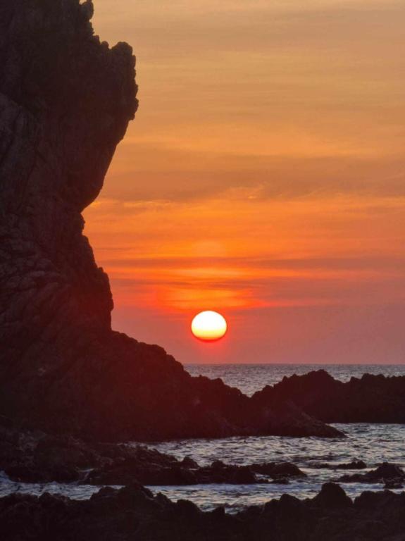 a sunset on the beach with the sun setting at El Nido mama hostel in El Nido