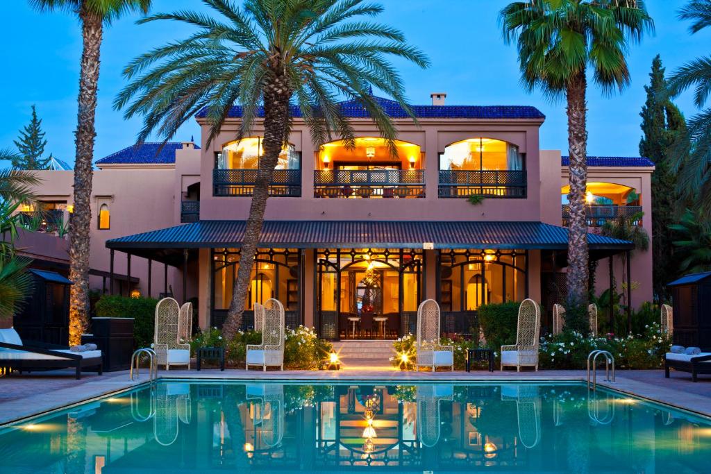 una casa grande con piscina frente a ella en Palais de l'O en Marrakech