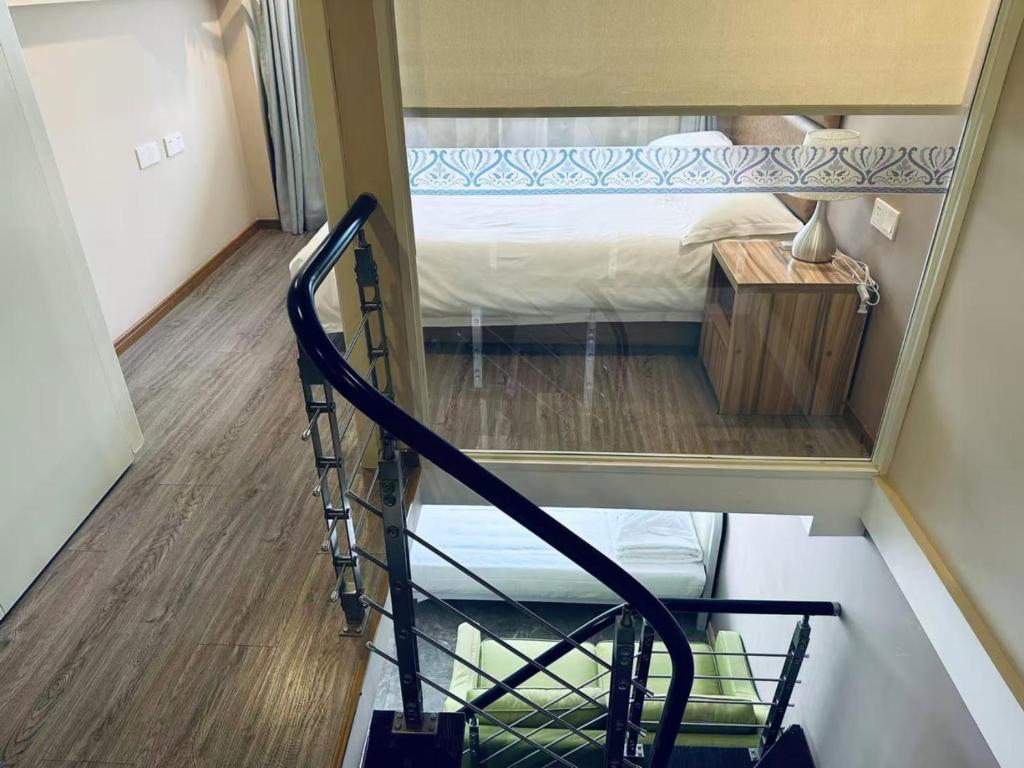 a room with a staircase leading to a bunk bed at Praise Hotel Xujiahui Zikawei Shanghai Stadium 上海徐家汇赞寓酒店上海体育馆地铁站店 in Shanghai