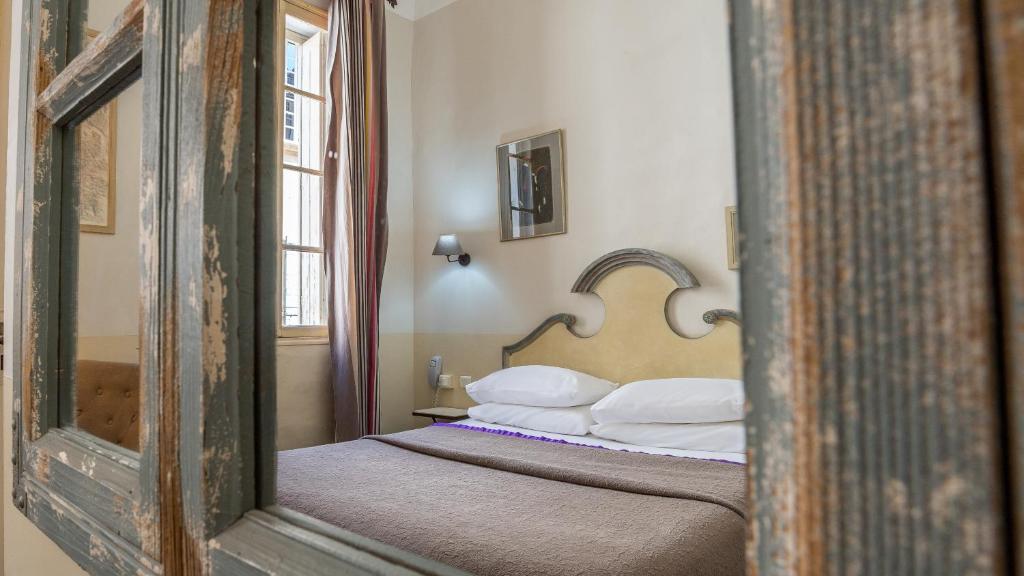 Postel nebo postele na pokoji v ubytování Hôtel Amphithéâtre
