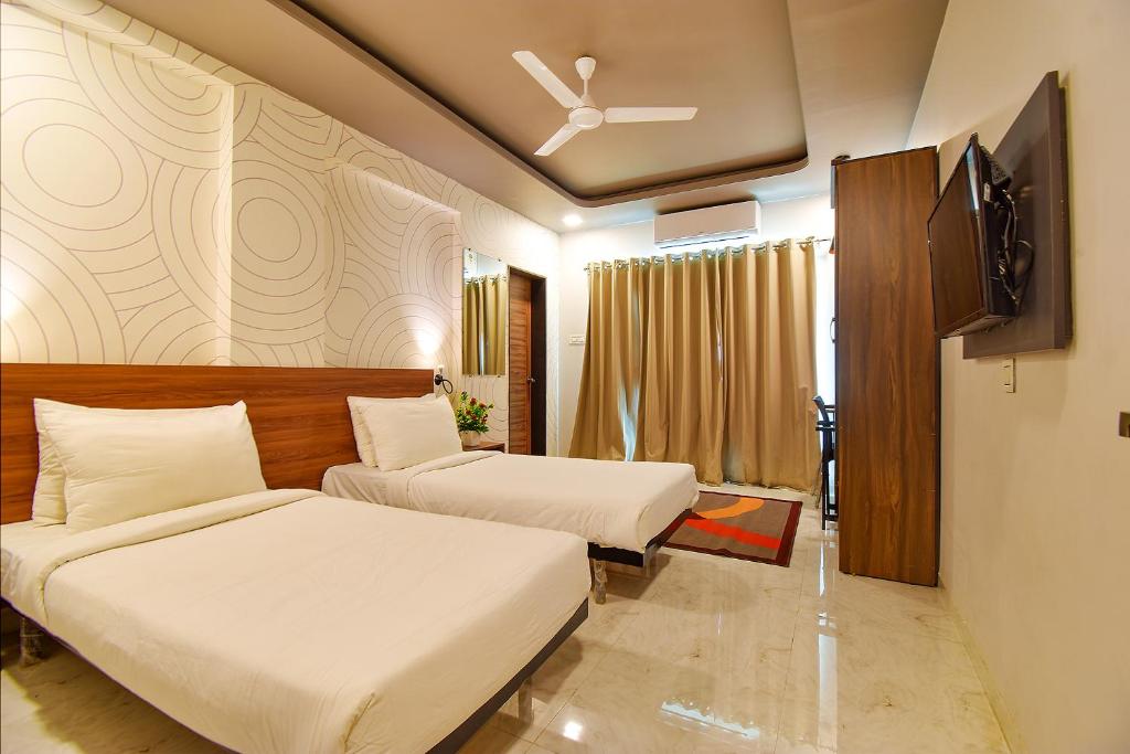 Postel nebo postele na pokoji v ubytování FabHotel Manomay Homes