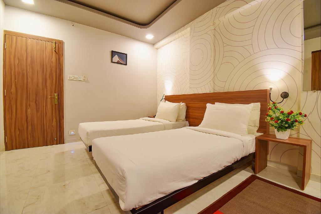 Postel nebo postele na pokoji v ubytování FabHotel Manomay Homes
