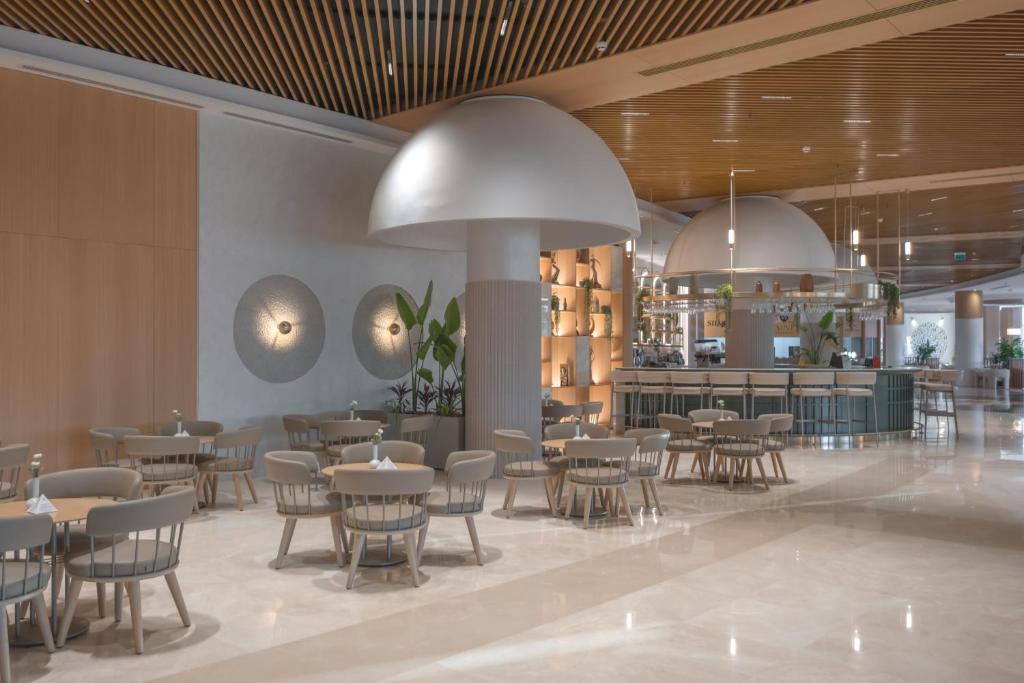 a restaurant with tables and chairs and a bar at Fame Residence Lara & Spa in Lara
