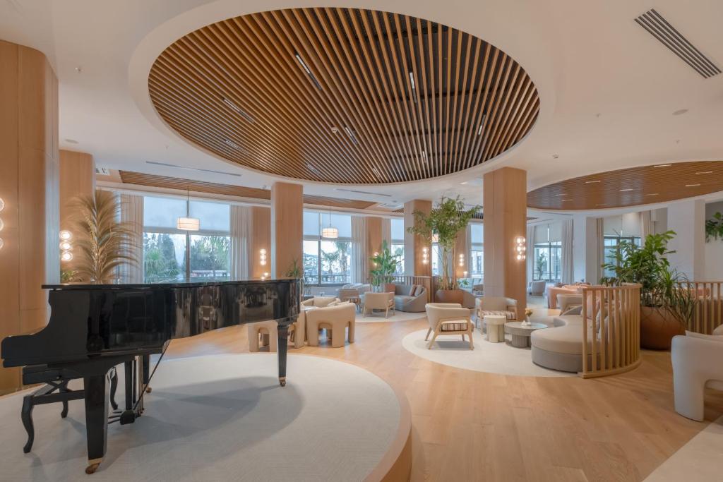 a living room with a piano and furniture at Fame Residence Lara & Spa in Lara
