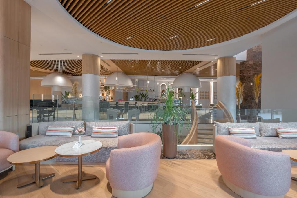 a lobby with tables and chairs and a bar at Fame Residence Lara & Spa in Lara