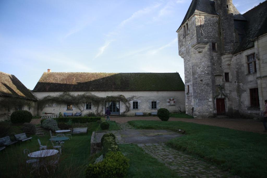 an old building with a tower with a grass yard at Chateau de Chémery in Chémery
