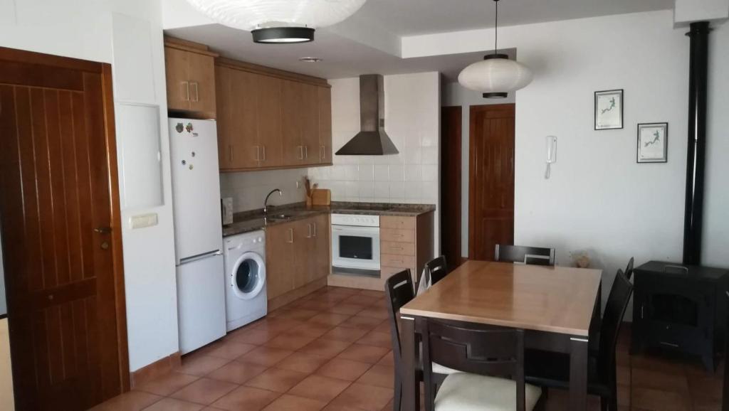 a kitchen with a table and a refrigerator and a sink at Apartamento Camarena de la Sierra in Camarena de la Sierra