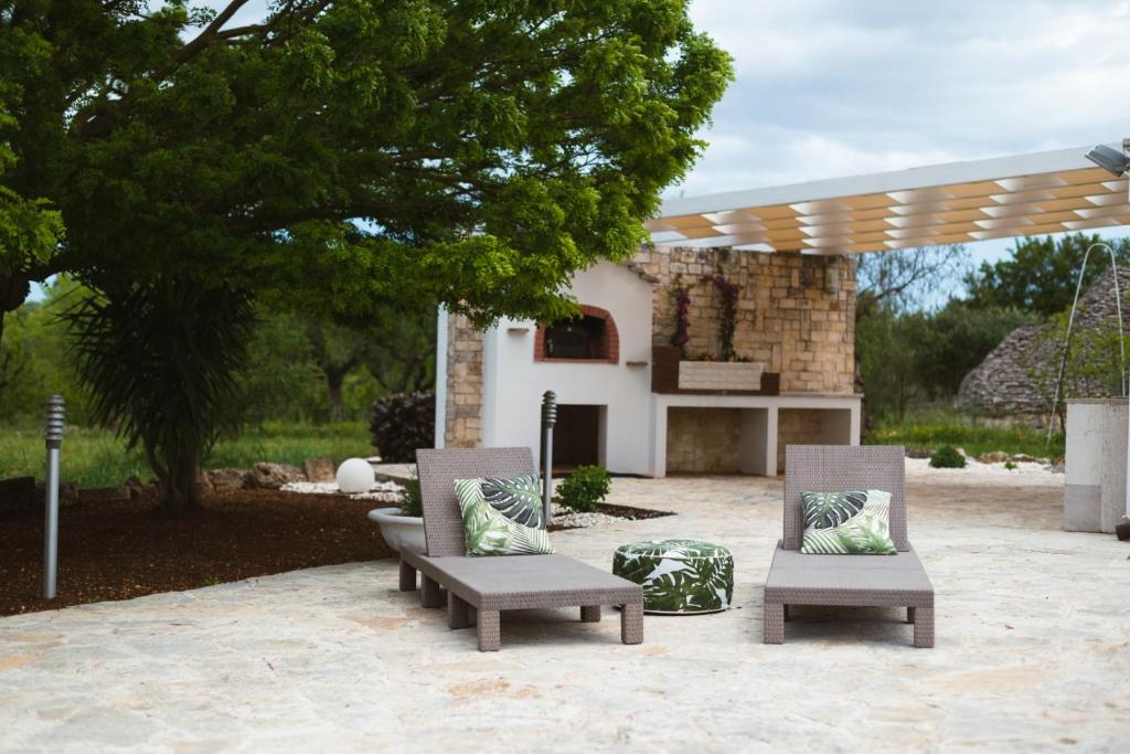 a patio with two lounge chairs and a fireplace at Villa Catia in Alberobello