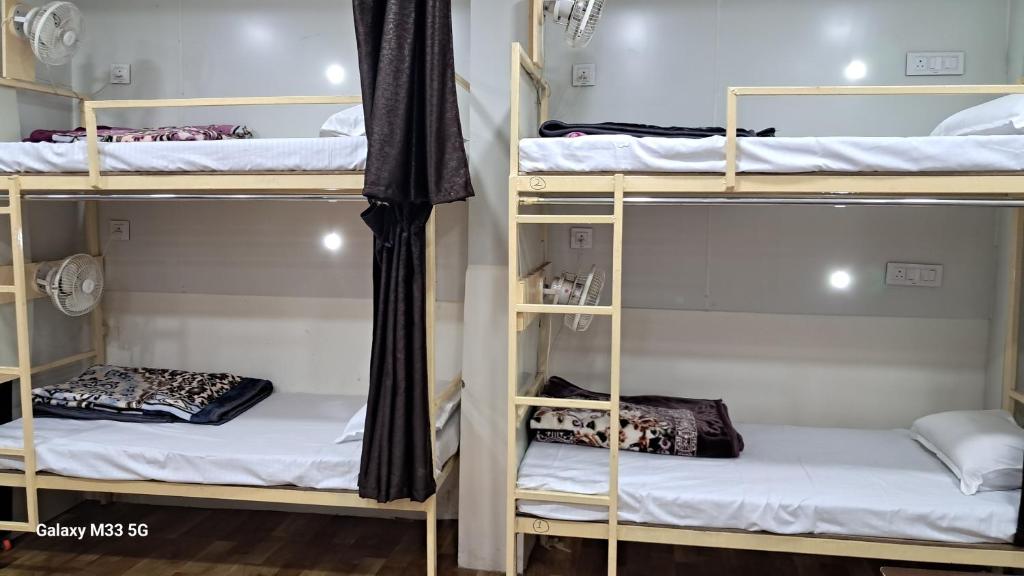 Postel nebo postele na pokoji v ubytování Maa Sheetala Dormitory