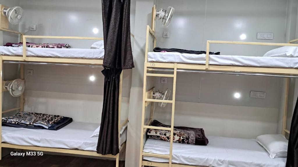 Postel nebo postele na pokoji v ubytování Maa Sheetala Dormitory