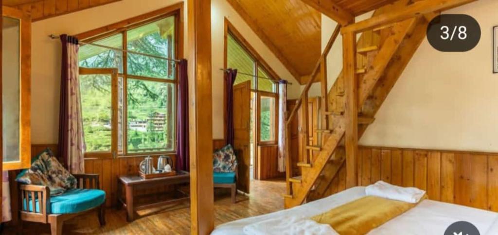 ein Schlafzimmer mit einem Bett und einer Treppe in einem Haus in der Unterkunft Majestic View Cottages in Jibhi