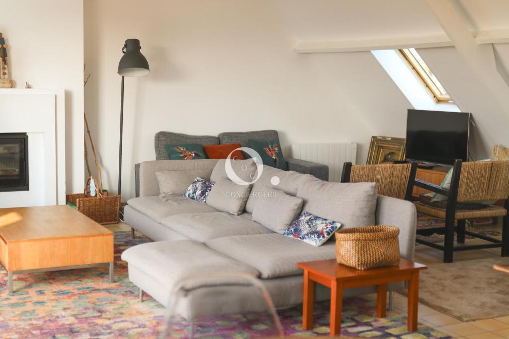 a living room with a couch and a table at COC - Villa Le Grand Terrain - Vue Mer in Wissant