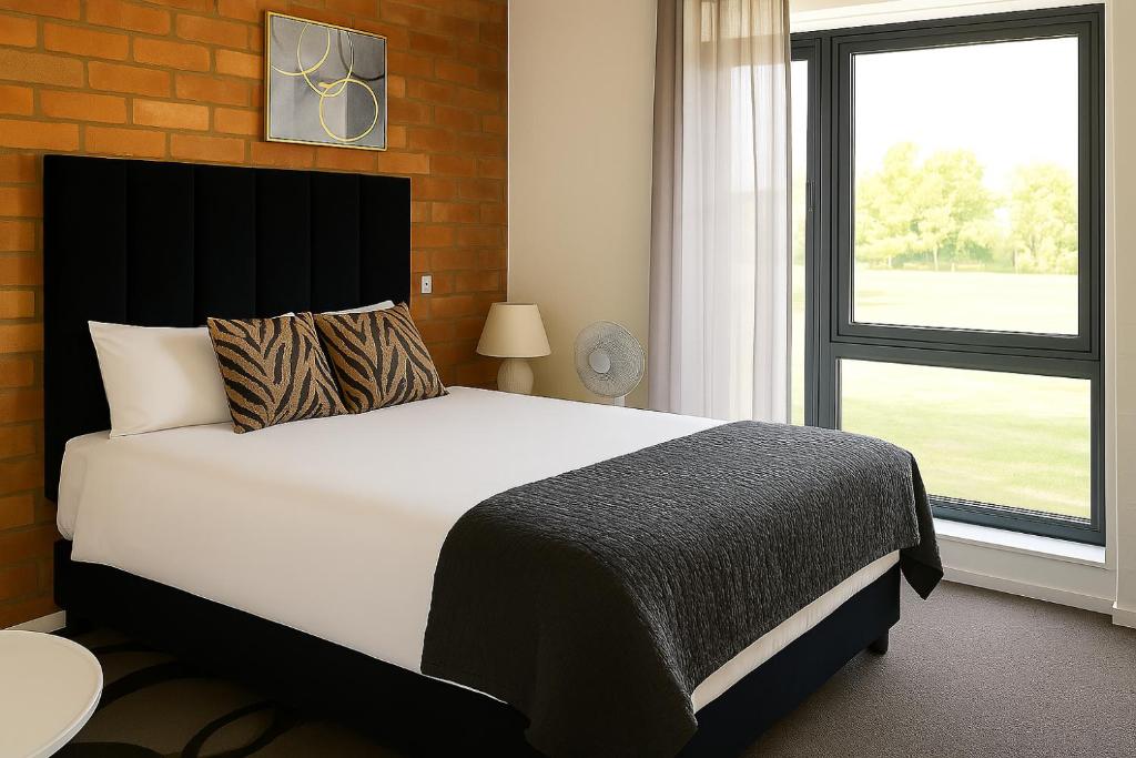 een slaapkamer met een groot bed en een raam bij Charming apartment With Private Balcony in Johannesburg