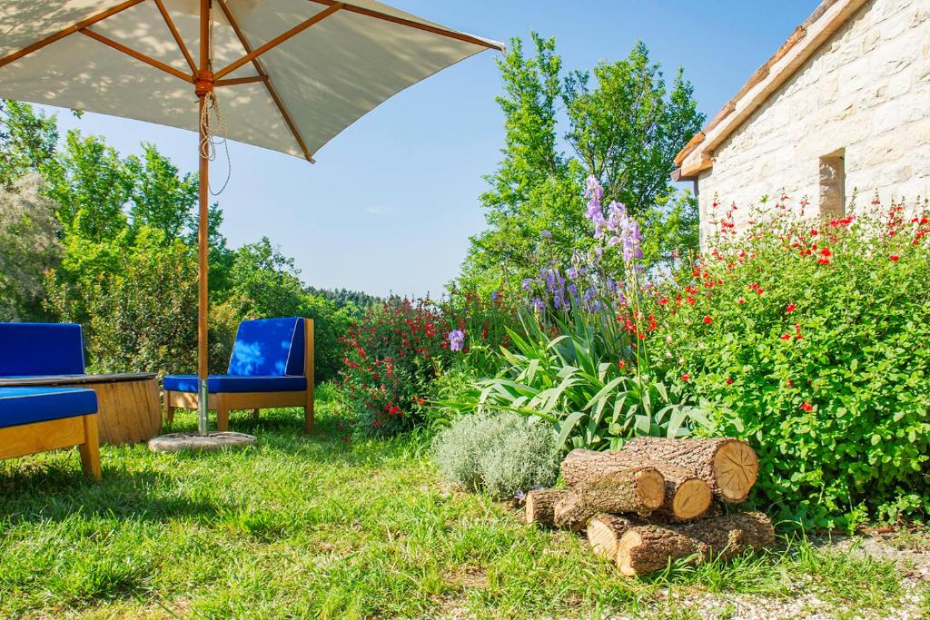 a garden with two chairs and an umbrella at Agriturismo Montecolombo by Il Ritorno in Sirolo