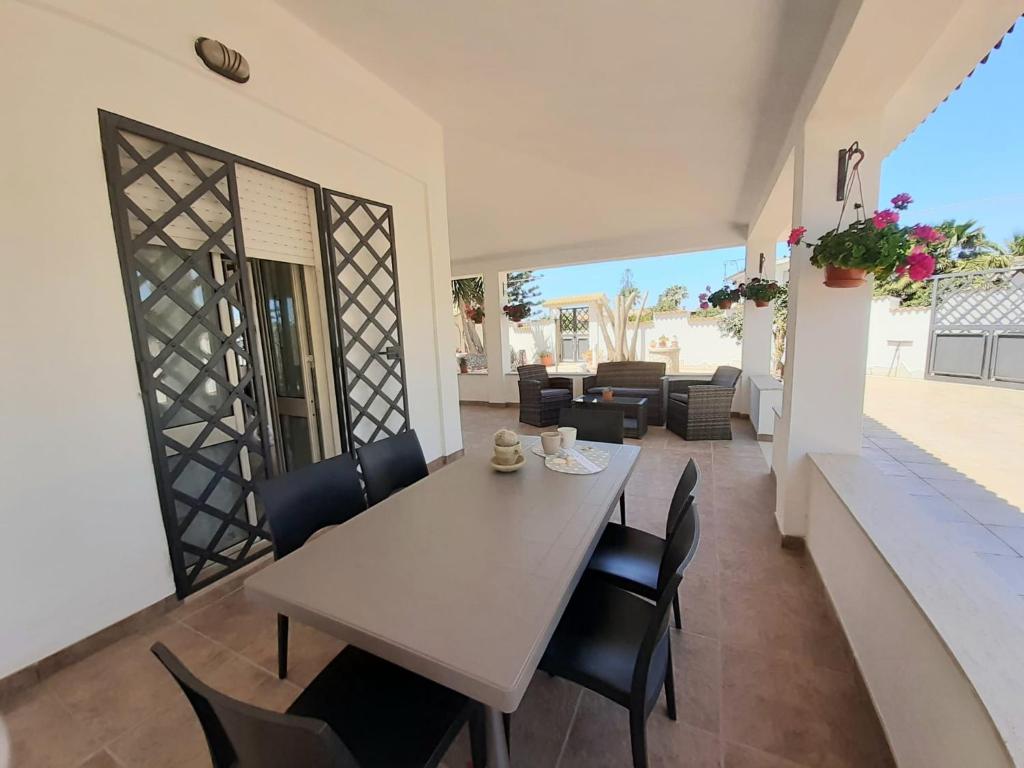 a dining room with a table and chairs at Casa Marina Maltese via ucca marina SANTA MARIA DEL FOCALLO ISPICA in Santa Maria Del Focallo