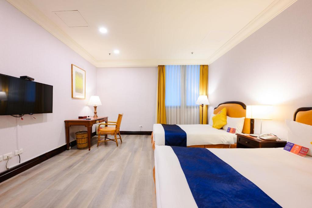 Postel nebo postele na pokoji v ubytování Wei-Yat Grand Hotel