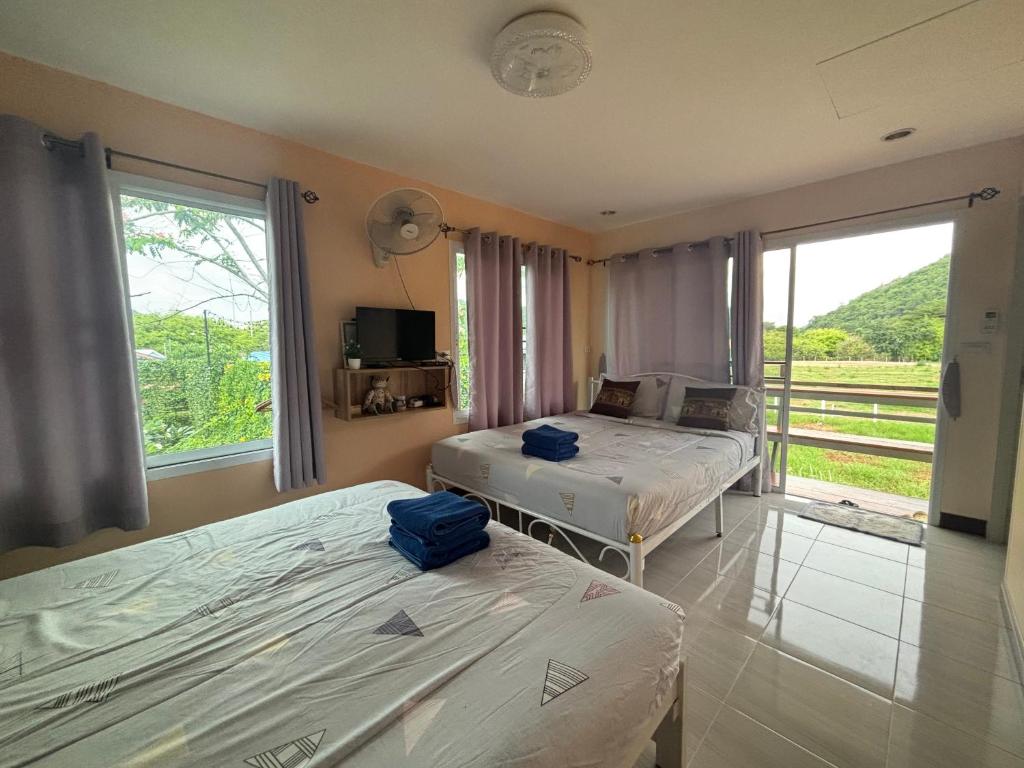 una camera con due letti e una grande finestra di Baan I-A-run Resort a Pak Chong