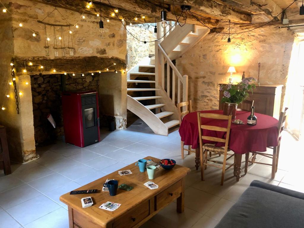 un salon avec une table et un escalier dans l'établissement L'Escaleyrou, gîte familial, charme & confort pour un séjour à côté de Lascaux, à Aubas