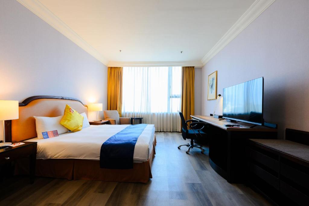 Postel nebo postele na pokoji v ubytování Wei-Yat Grand Hotel
