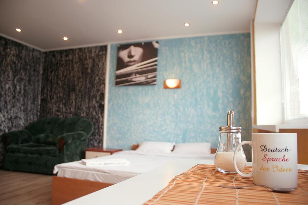 a hotel room with a bed and a coffee mug on a table at Apartament Erfolg 3 in Daugavpils