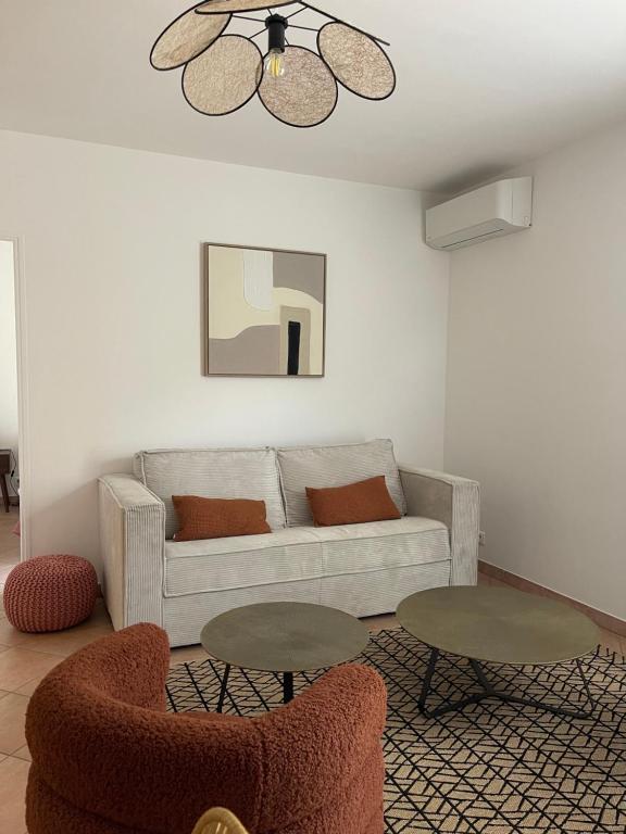 ein Wohnzimmer mit einer Couch und zwei Tischen in der Unterkunft Appartement vue Mer en plein centre in Calvi