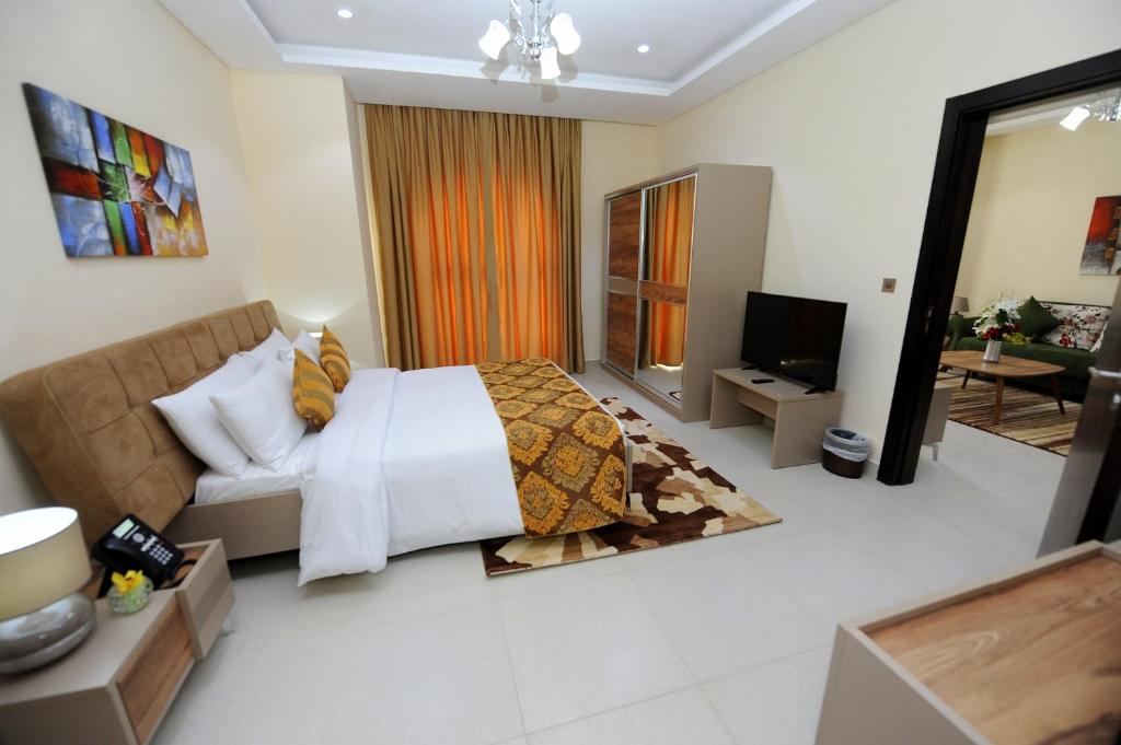 Al Mansour Park Inn Hotel&Apartment في الدوحة: غرفة نوم مع سرير وغرفة معيشة