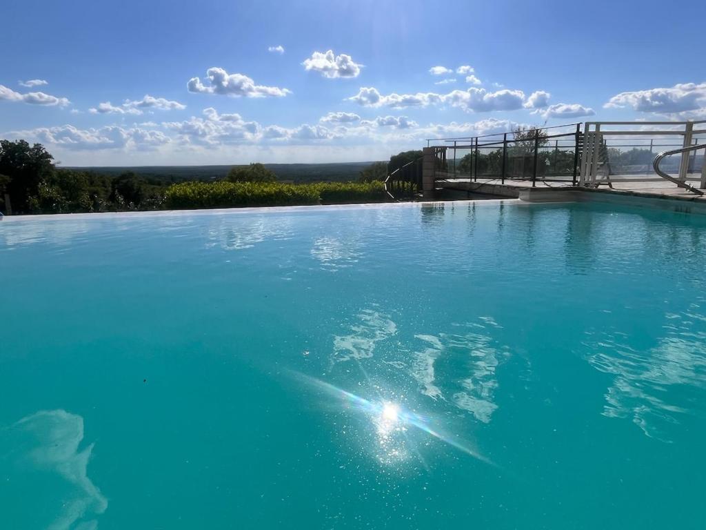 une grande piscine d'eau bleue avec un pont dans l'établissement Vue exceptionnel-Piscine chauffée-salle de sport, à Saint-Jean-de Laurs