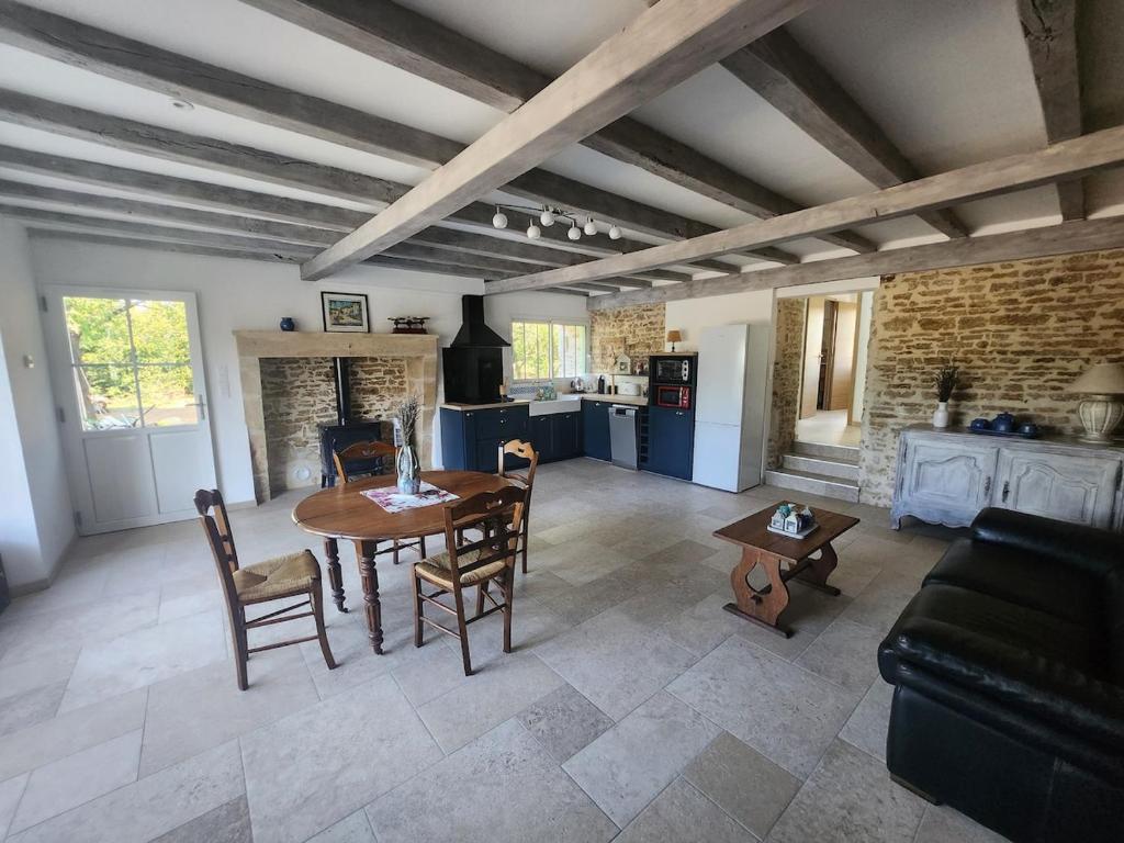 un salon avec une table et une cuisine dans l'établissement La Petite Maison d Exireuil, à La Celle-sous-Gouzon