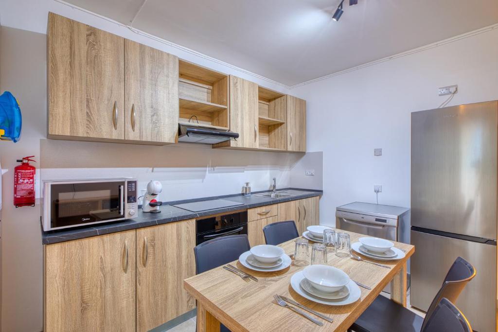 a kitchen with a dining table and a refrigerator at New! Modern Studio in central Malta by SF Homes in Msida