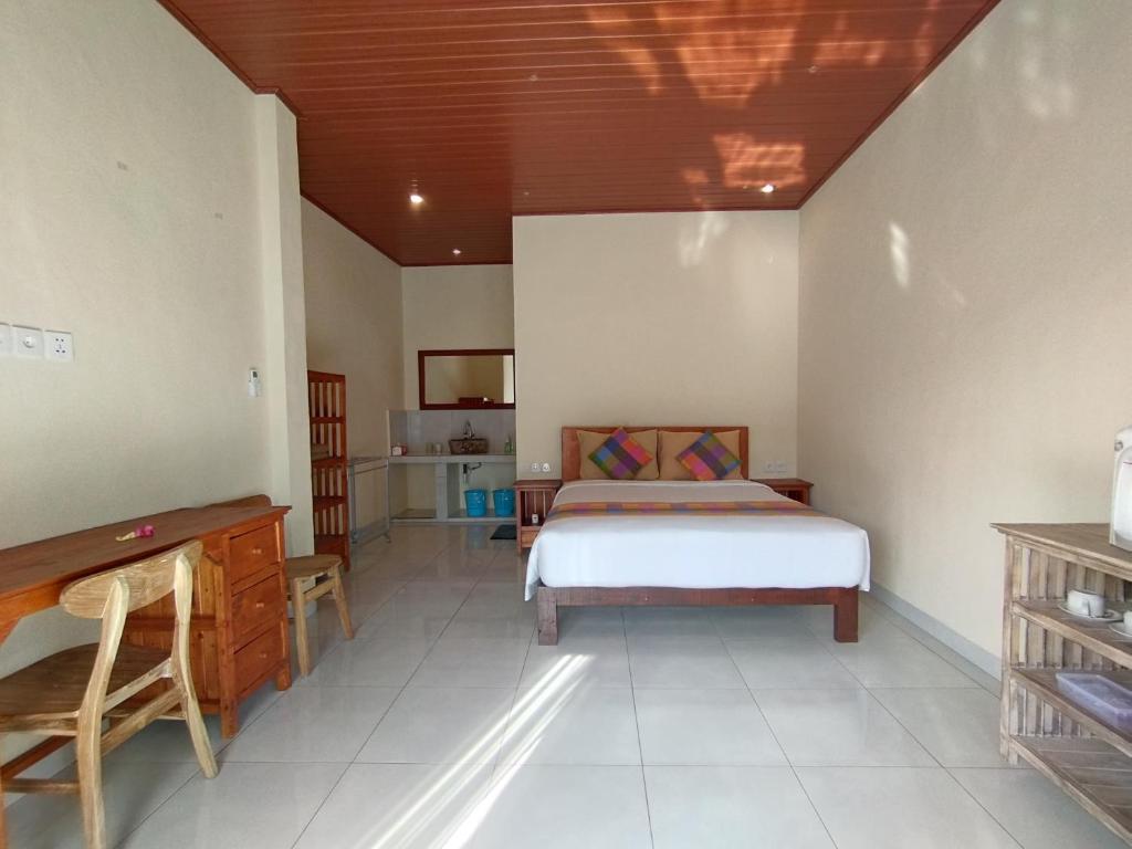 sypialnia z łóżkiem i biurkiem w obiekcie Meme Lan Bape Guest House w mieście Ubud
