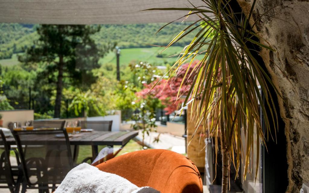une plante dans un vase posée à côté d'un mur de pierre dans l'établissement Le boum coeur douillet troglodyte jardin wifi pk, à Millau