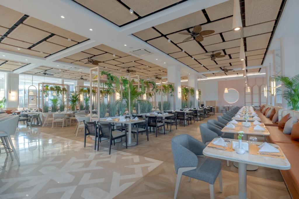 a rendering of a restaurant with tables and chairs at Fame Residence Lara & Spa in Lara