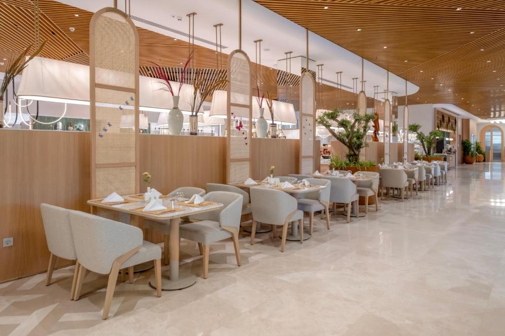 a restaurant with tables and chairs in a building at Fame Residence Lara & Spa in Lara