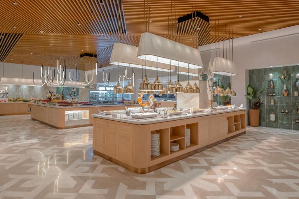 a restaurant with a large counter in a room at Fame Residence Lara & Spa in Lara