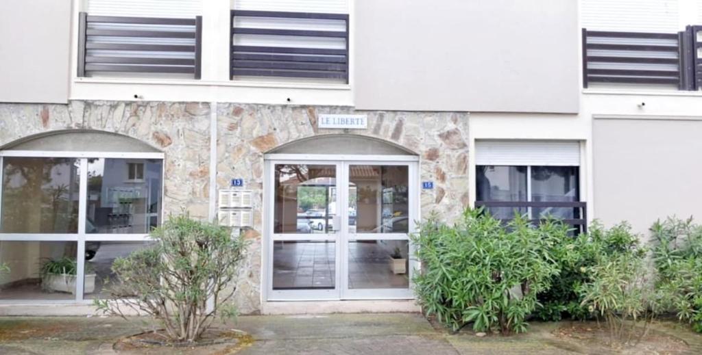 - un bâtiment blanc avec une porte et 2 fenêtres dans l'établissement Studio en bord de mer, à Saint Cyprien Plage