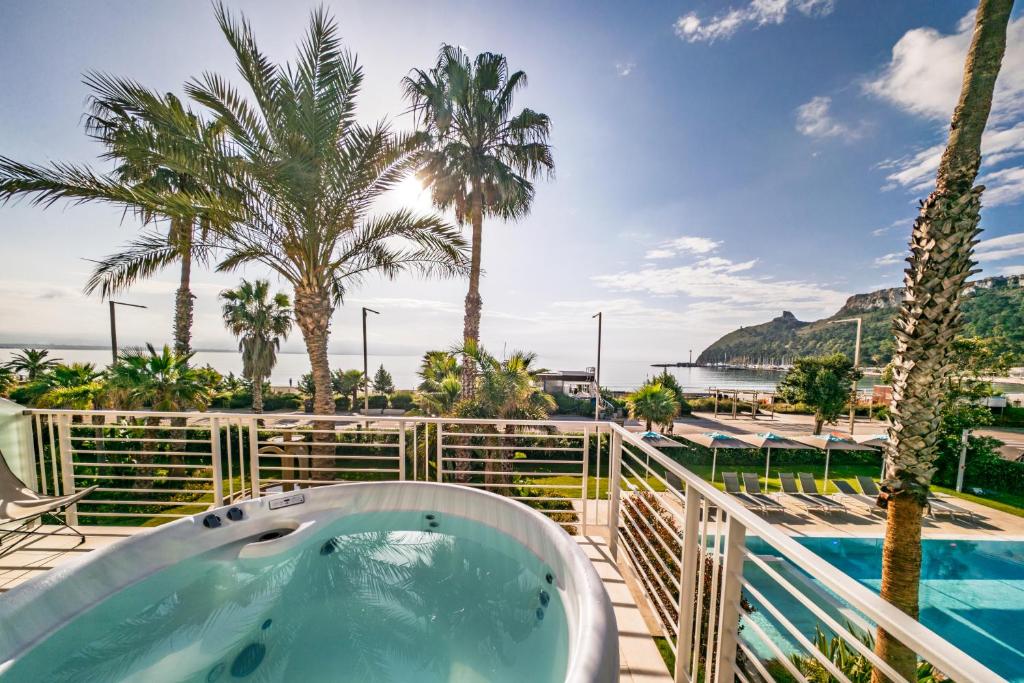 a hot tub on a balcony with palm trees at Hotel Nautilus Excelsior - Adults Only in Cagliari