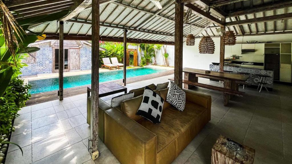 a living room with a couch and a swimming pool at Villa Louise in Badung