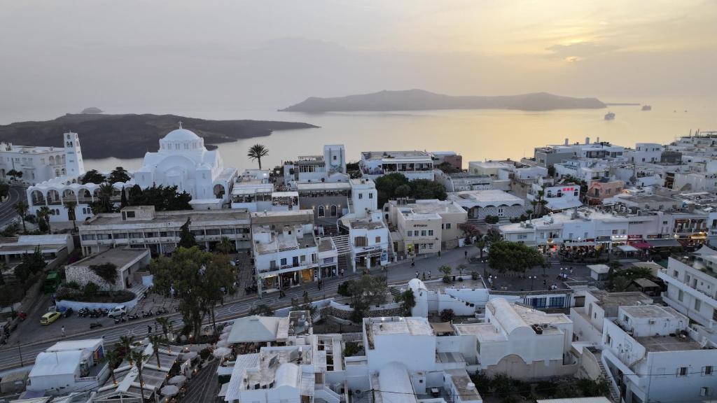 an aerial view of a white city with a body of water at Hotel Santorini in Fira