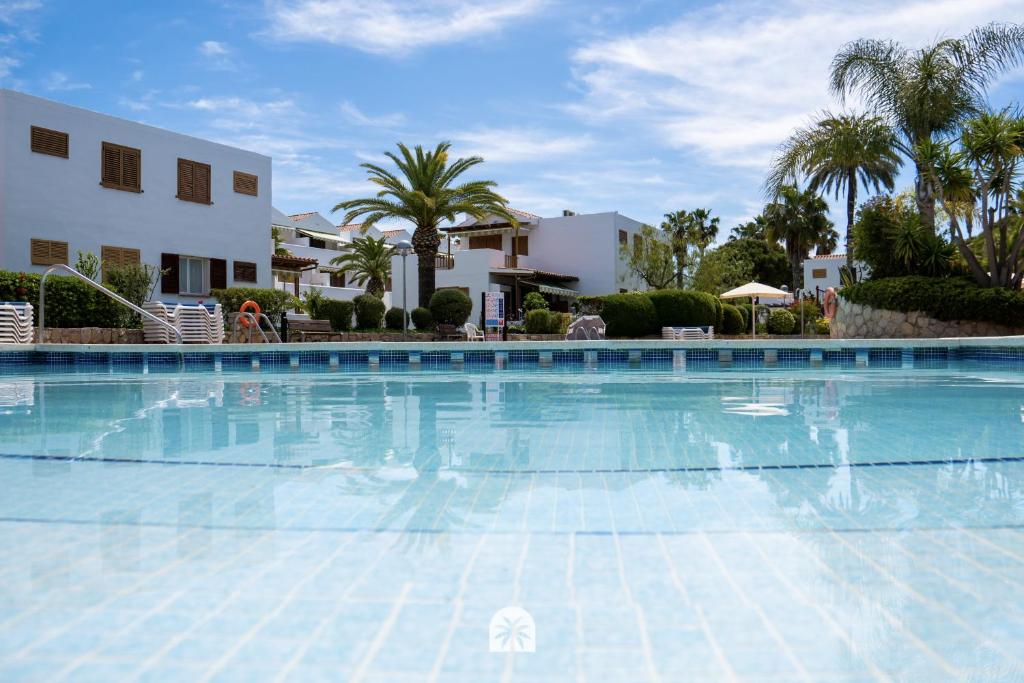 a large swimming pool in front of a building at Mediterranean Way - Punta Prima 17 in La Pineda