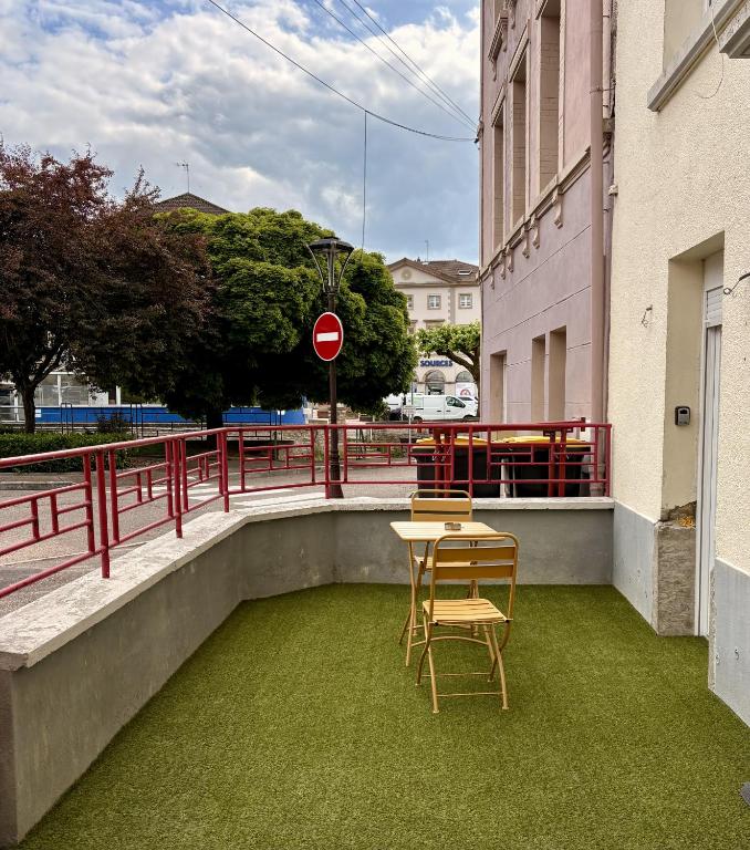 d'une table et de chaises sur un balcon avec de l'herbe verte dans l'établissement Petite merveille, à Vittel
