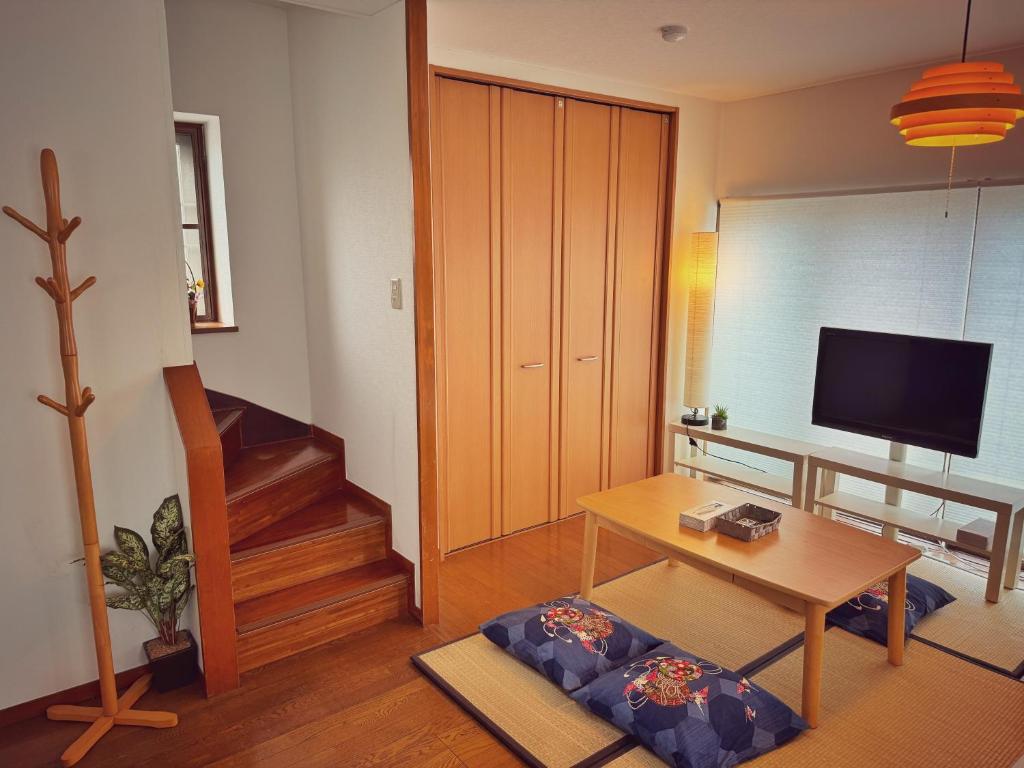 a living room with a table and a television at Uhome Ueno Hotel in Tokyo