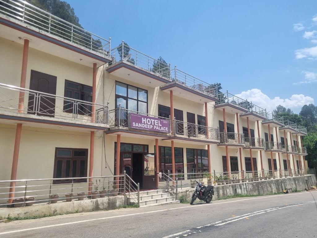 a building with a motorcycle parked in front of it at Hotel Sandeep palace in Jāmb