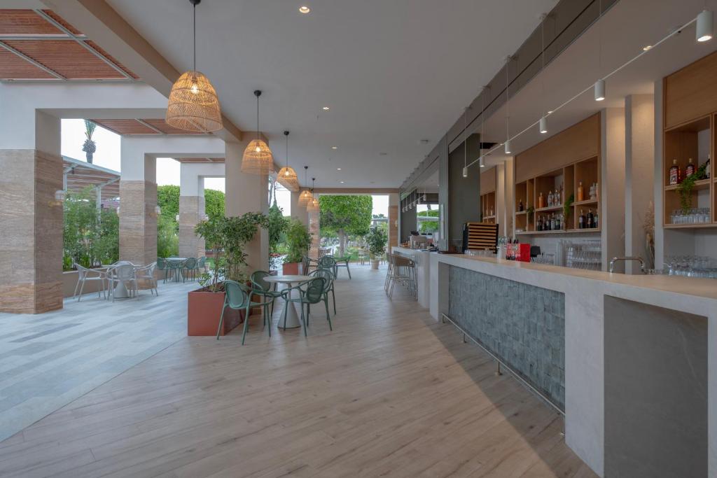 a restaurant with a bar with chairs and tables at Fame Residence Lara & Spa in Lara