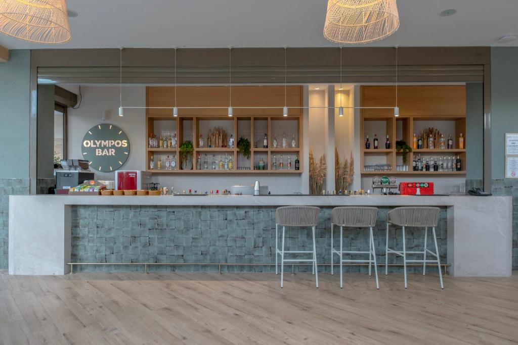 a bar in a restaurant with three stools at Fame Residence Lara & Spa in Lara