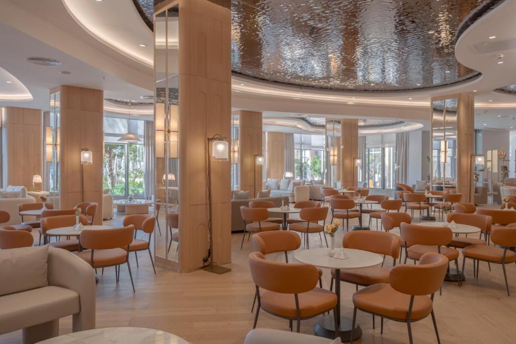 a restaurant with tables and chairs in a room at Fame Residence Lara & Spa in Lara