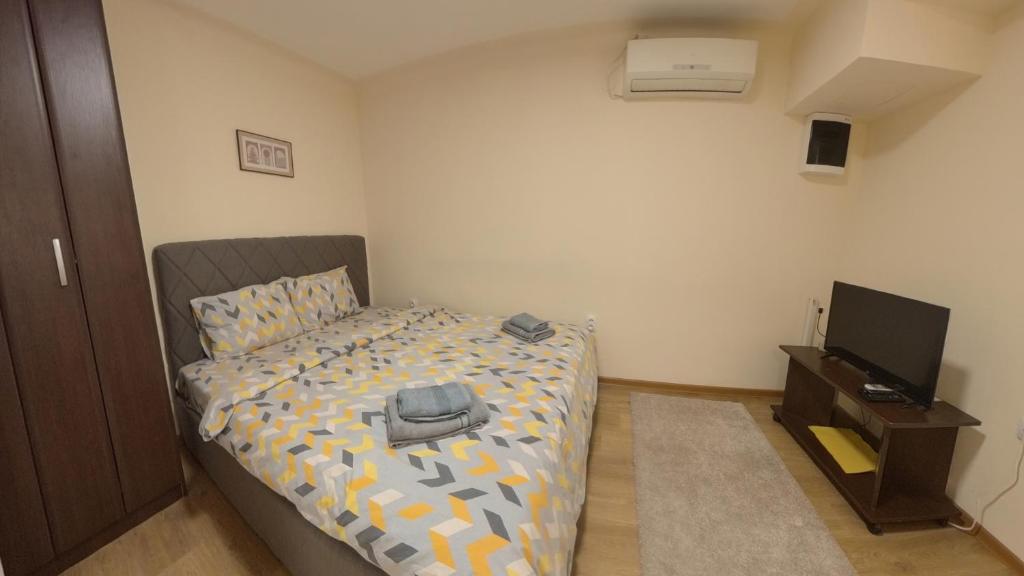 Un pequeño dormitorio con una cama y un televisor. en Center Point apartment, en Belgrado