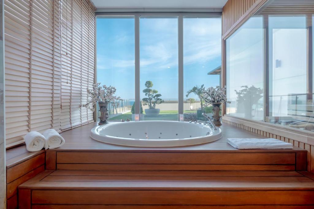 a large bath tub in a room with large windows at Fame Residence Lara & Spa in Lara