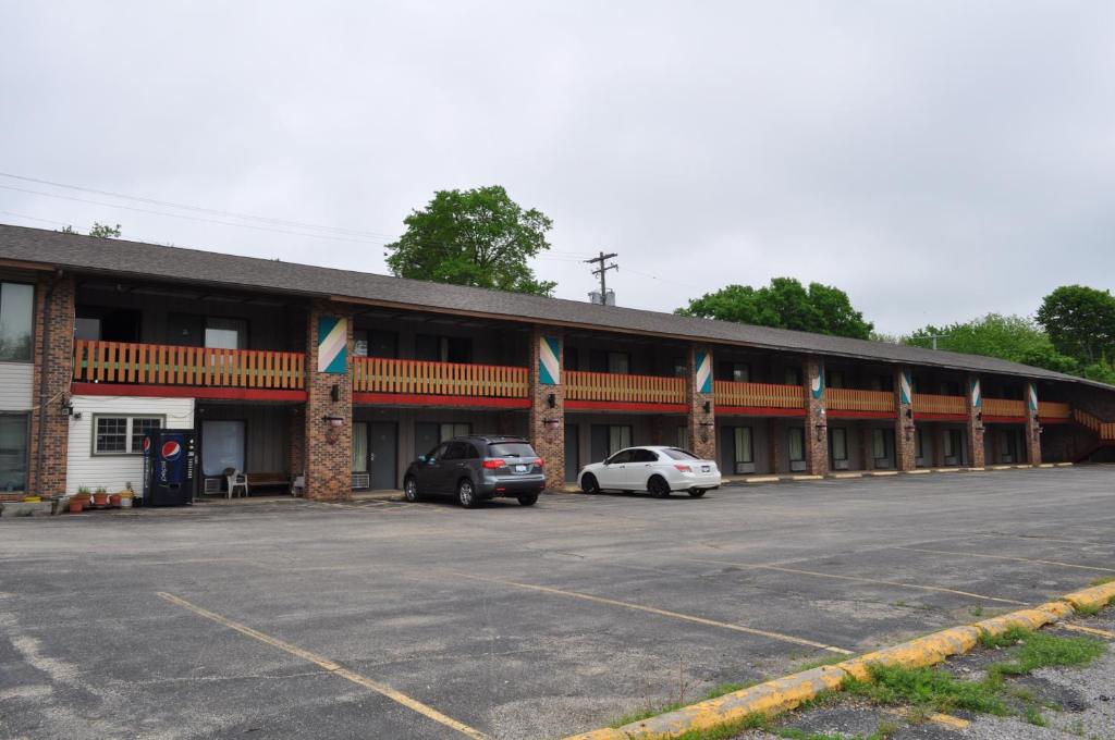 a building with two cars parked in a parking lot at Kewanee Motor Lodge in Kewanee